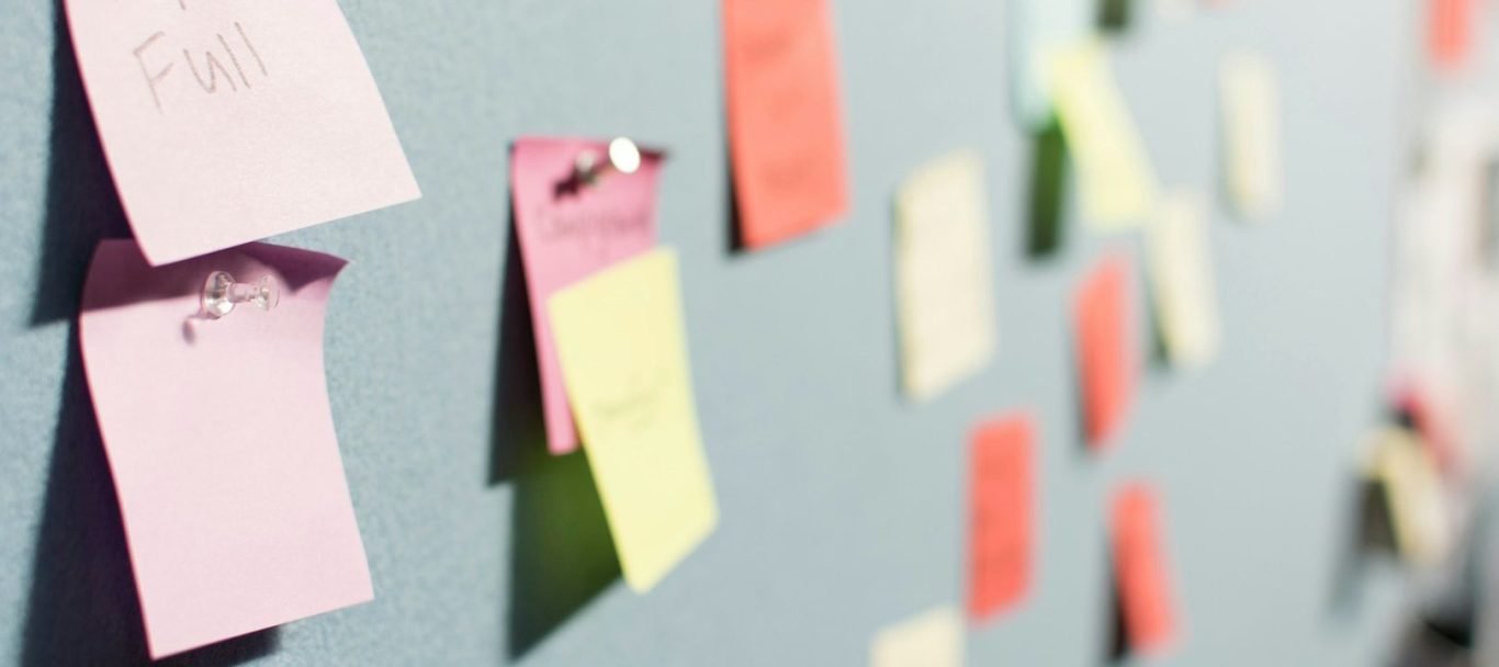 Zettel Bunte Haftnotizen auf einer Wand in unscharfer Perspektive für ein gutes Brand Naming.