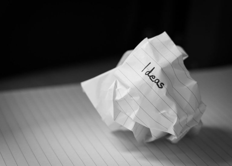 papier Zusammengeknülltes Papier mit der Aufschrift "Ideen" auf einem linierten Blatt bei Namensentwicklung.
