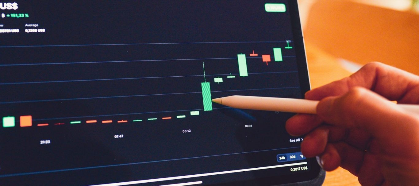 chart Hand mit einem Stylus zeigt auf ein Finanzdiagramm mit steigenden Kursen für Firmennamen finden.