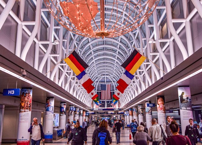 halle Ein Flughafeninneres mit Flaggen verschiedener Länder und Reisenden bei Namensentwicklung.